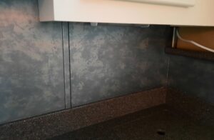 Close up view showing the dark of the counter and the backsplash.